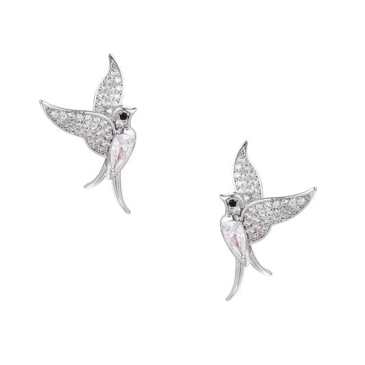 Pair of white gold-plated hummingbird stud earrings with pavé zirconia stones and teardrop crystal bodies on cream background