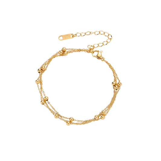 Three-strand gold-plated bracelet with clustered ball beads and adjustable clasp on cream background