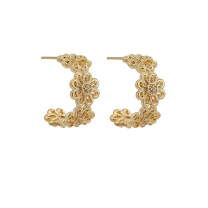 Gold hoop earrings with intricate three-dimensional floral filigree pattern in 14K gold plated brass on cream background