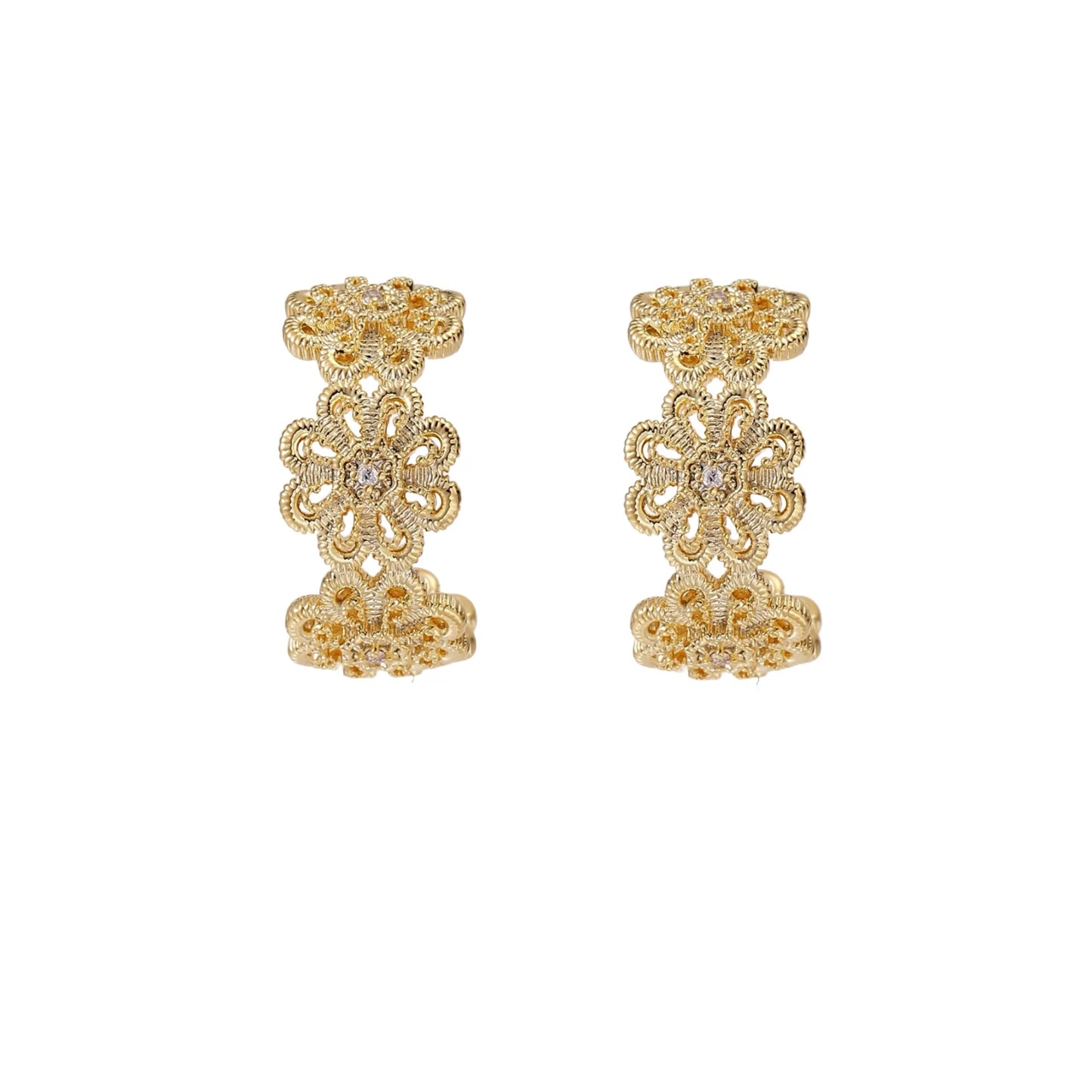 Gold hoop earrings with intricate three-dimensional floral filigree pattern in 14K gold plated brass on cream background