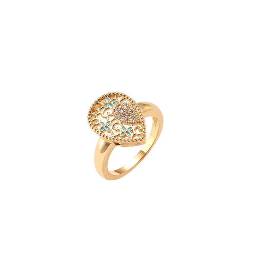 Teardrop-shaped gold-plated ring with turquoise enamel flowers and crystal pavé detail on cream background