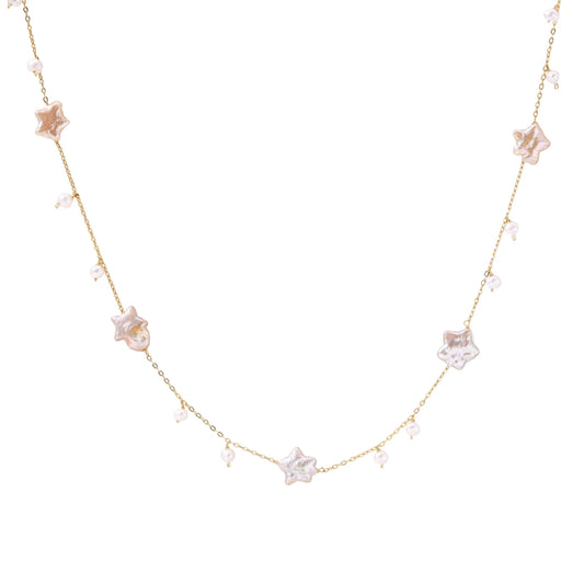 Gold vermeil chain with iridescent star-shaped baroque pearls and small round freshwater pearl drops on cream background.