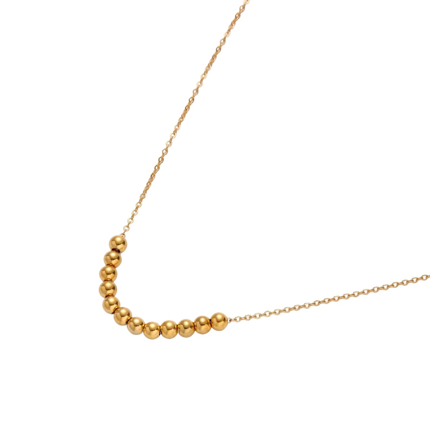 Delicate gold-plated necklace with graduated spherical beads forming gentle smile curve on beige background