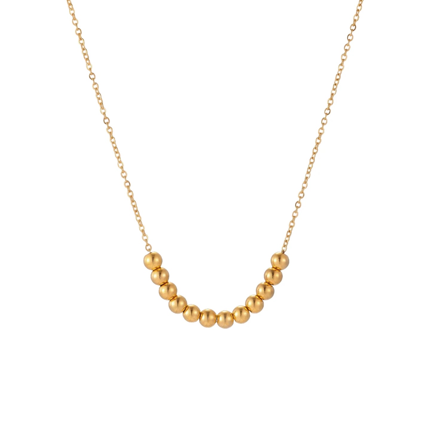 Delicate gold-plated necklace with graduated spherical beads forming gentle smile curve on beige background