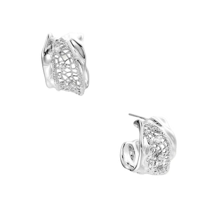 Close-up of sculptural hoop earrings with lattice center band and smooth twisted edges in white gold-plated brass with zirconia