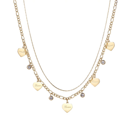 Gold layered necklace set with engraved heart pendants and crystal accents on cream background