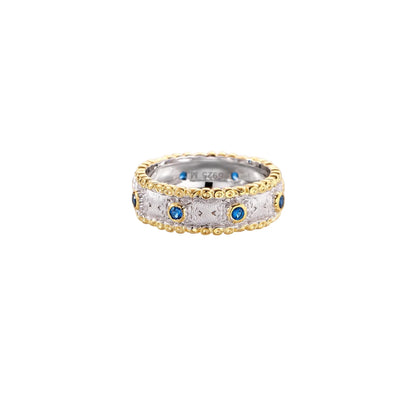 Two-tone ring with brushed silver center, gold beaded edges, and blue zirconia stones on white background.