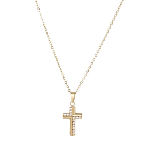 Delicate 14K gold-plated cross pendant with crystal accents on fine chain against cream background