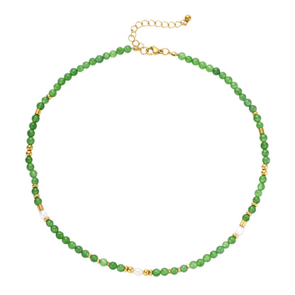 Layered necklace with green stone beads, gold spacers, white accents, and protective eye pendant on cream background.