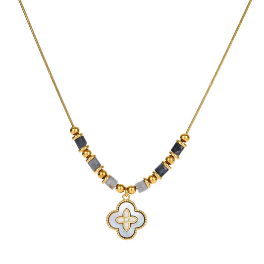 Gold-toned beaded necklace with grey stones and quatrefoil abalone shell pendant on cream background.